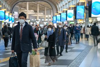 जापान की राजधानी टोक्यो में, कोविड-19 से बचाव के लिये मास्क पहने हुए लोग.