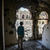 也门塔伊兹，一个男孩站在靠近活跃的前线的一栋建筑受损的内部。