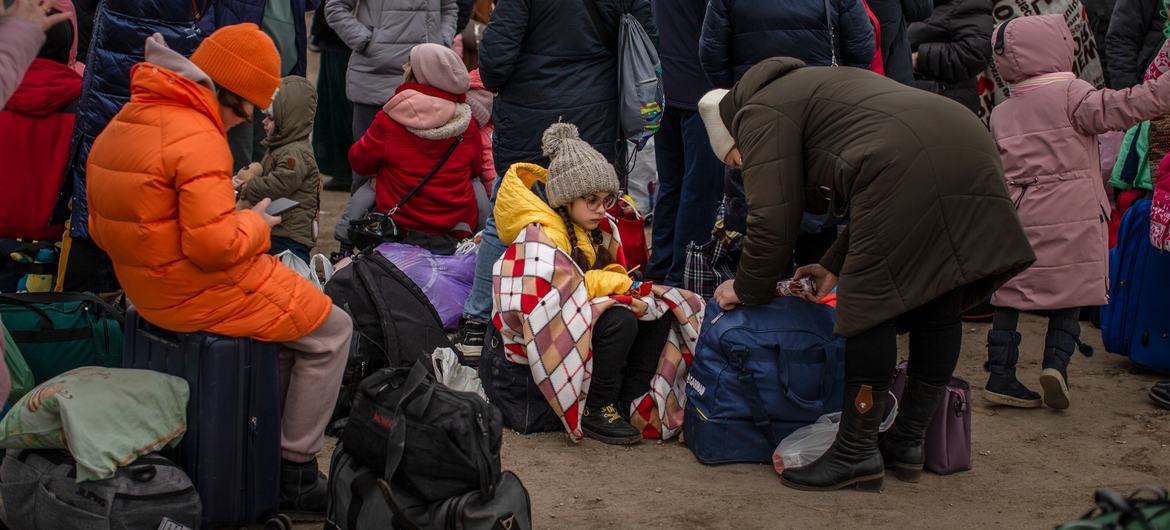 Украинские беженцы, некоторые с детьми, прибывают на пограничный пункт Паланка в Молдове.