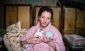 乌克兰基辅一间临时病房里，一名妇女抱着她刚出生的婴儿。