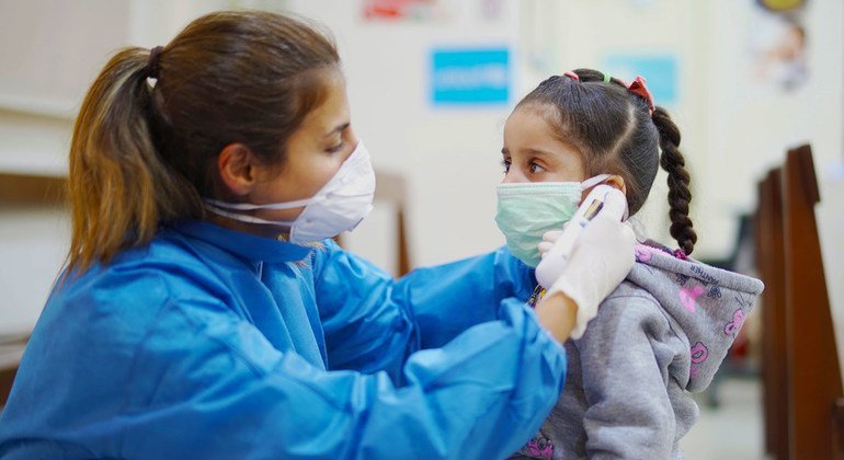Una enfermera toma la temperatura a una niña en un Centro de Atención Primaria de Salud en Beirut, Líbano, durante el brote de COVID-19.