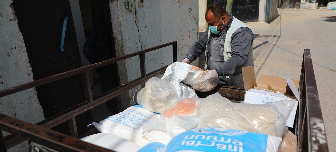ग़ाज़ा के परिवारों को संयुक्त राष्ट्र सहायता एजेंसी के ज़रिए खाद्य सामग्री के पैकेट वितरित किये जाते हुए.