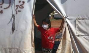 叙利亚西北部伊德利卜省，一名女童站在境内流离失所者安置点内的一顶帐篷前。