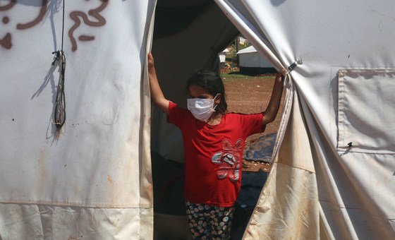 فتاة صغيرة تقف أمام خيمتها في أحد مخيمات النازحين في شمال إدلب بسوريا.