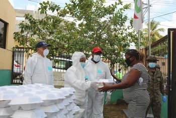 A woman in the Dominican Republic receives food from a Government soup kitchen set up to help fight hunger triggered by the COVID-19 pandemic.