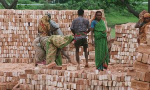 Workers stack bricks at a factory near Dhaka in Bangladesh.