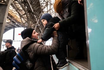 أسرة هربت من ماريوبول ووصلت إلى محطة القطارات في لفيف في أوكرانيا.