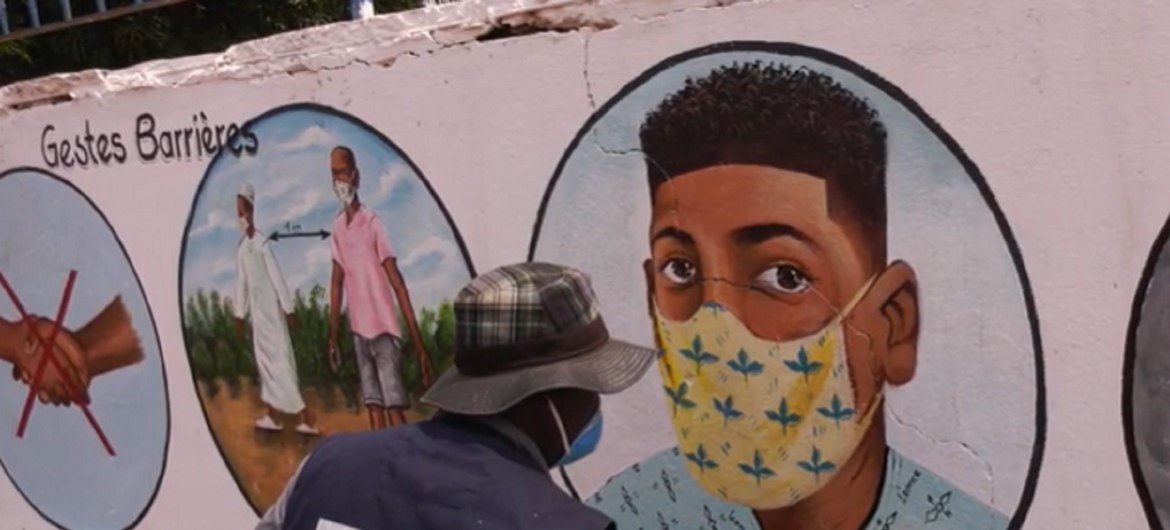 فنان في جمهورية إفريقيا الوسطى يرسم على الجدران نصائح مختلفة حول كيفية الحماية من كوفيد-19.
