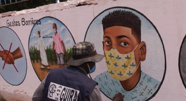 मध्य अफ़्रीकी गणराज्य में एक कलाकार दीवारों पर कोविड-19 के ऐहतियाती उपायों पर चित्रकारी कर रहा है.