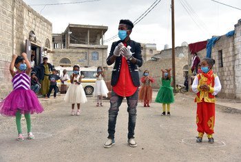 A volunteer guides and instructs girls in a town in Yemen, on the proper way to wash their hands.