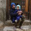 一名来自厄立特里亚的移民抱着她6个月大的孩子，在利比亚的黎波里的一处房屋前。（2019年2月图片）
