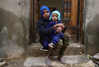 一名来自厄立特里亚的移民抱着她6个月大的孩子，在利比亚的黎波里的一处房屋前。（2019年2月图片）