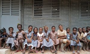 Children sit in front of their new school made out of recycled plastic bricks in Sakassou, in the Center of Côte d'Ivoire.