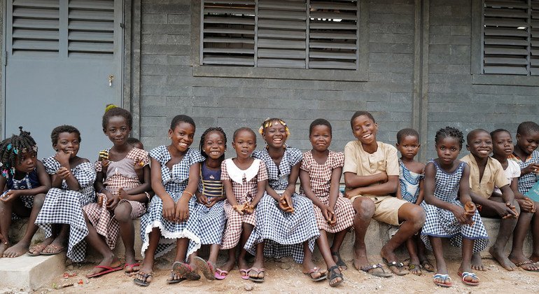 Des enfants assis devant leur nouvelle école faite de briques en plastique recyclé à Sakassou, dans le centre de la Côte d'Ivoire.