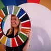 今年9月联合国大会第74届会议高级别会议期间，一名与会者手持2030年可持续发展议程图标留影。