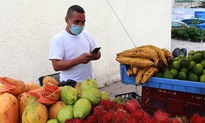 Hombre vendiendo en su puesto de verduras en Tegucigalpa, Honduras.