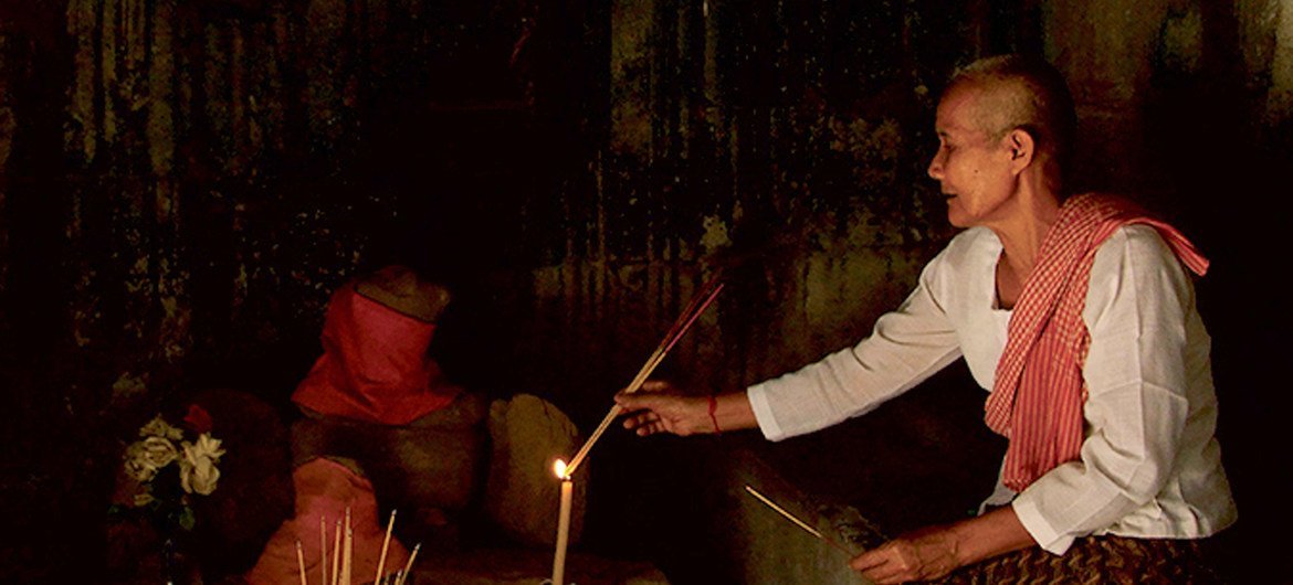一位比丘尼在柬埔寨吴哥窟的一处遗迹内诵经祷告。
