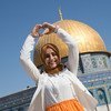 Une jeune Palestinienne qui a quitté la Cisjordanie pour la première fois se tient devant le Dôme du Rocher à Jérusalem.