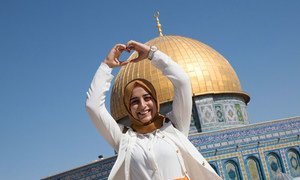 Une jeune Palestinienne qui a quitté la Cisjordanie pour la première fois se tient devant le Dôme du Rocher à Jérusalem.