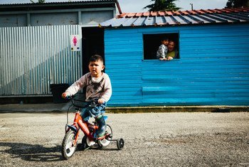 希腊莱斯沃斯岛上的一处难民居住点内，一个男孩正在骑自行车。