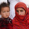 Une fillette de 12 ans tient sa petite sœur dans ses bras devant un centre de nutrition dans un camp pour personnes déplacées près de la ville occidentale de Herat. Les deux filles sont venues ici avec leur famille pour échapper aux combats dans leur prov