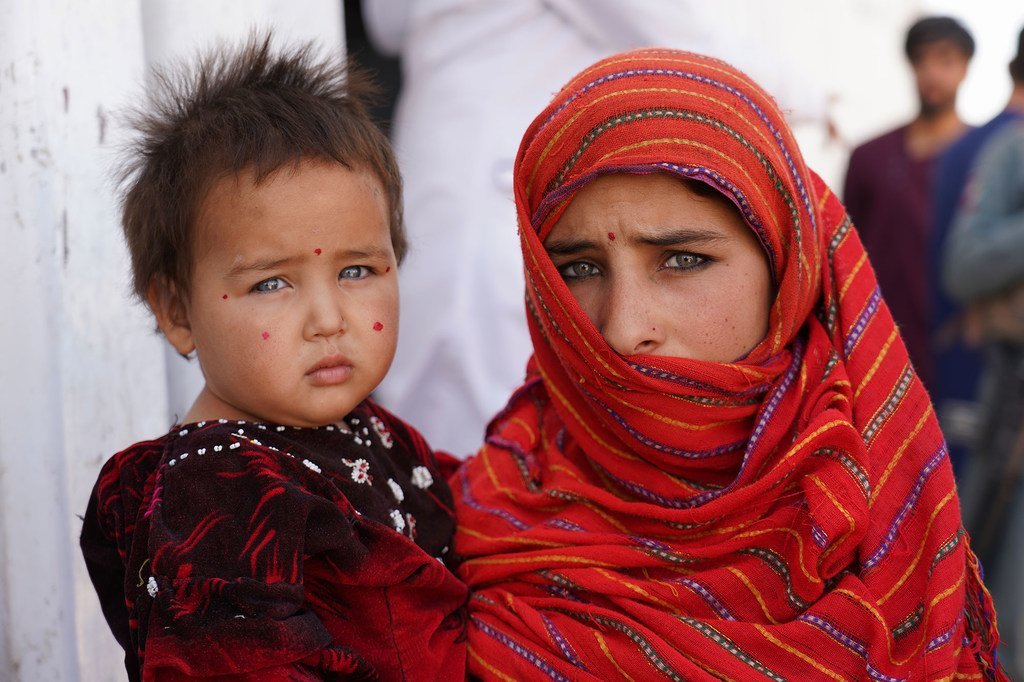 Une fillette de 12 ans tient sa petite sœur dans ses bras devant un centre de nutrition dans un camp pour personnes déplacées près de la ville occidentale de Herat. Les deux filles sont venues ici avec leur famille pour échapper aux combats dans leur prov
