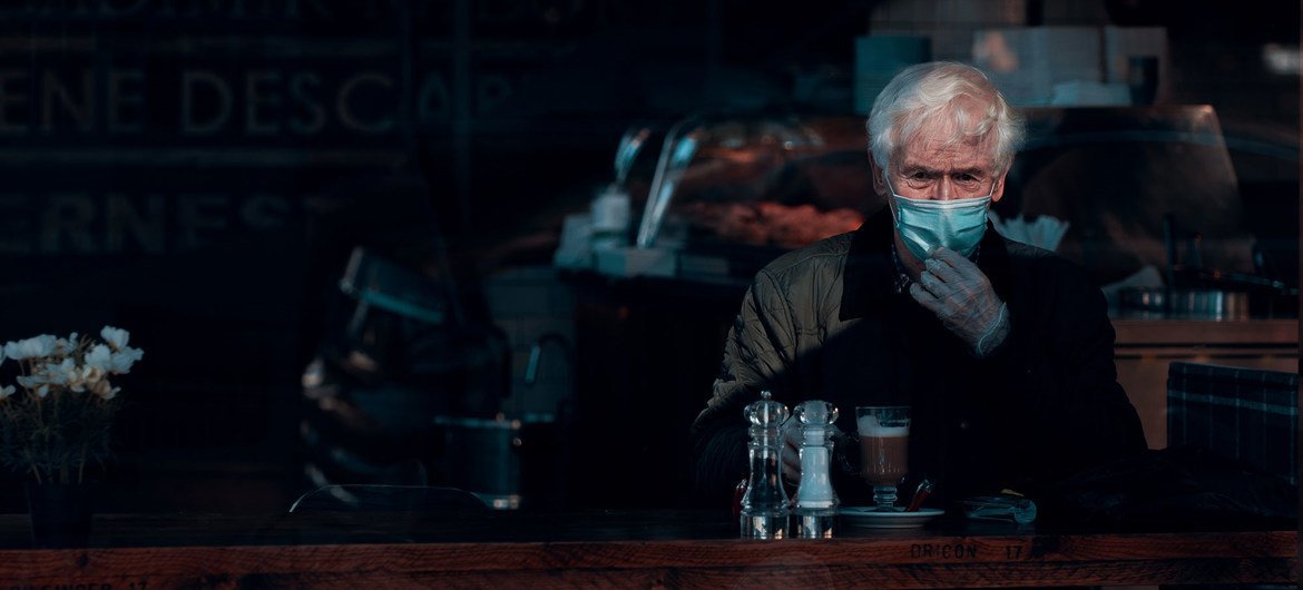 Un hombre lleva una mascarilla y guantes en un café de Glasgow, Escocia. 