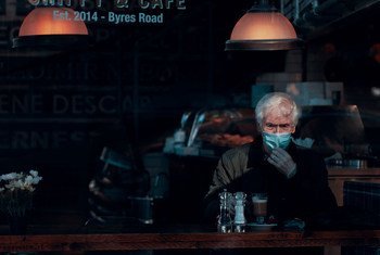 स्कॉटलैंड के एक कैफ़े में बैठा एक व्यक्ति मास्क और दस्ताने पहने हुए, जिन्हें कोरोनावायरस से बचने का कारगर ऐहतियाती उपाय बताया गया है.