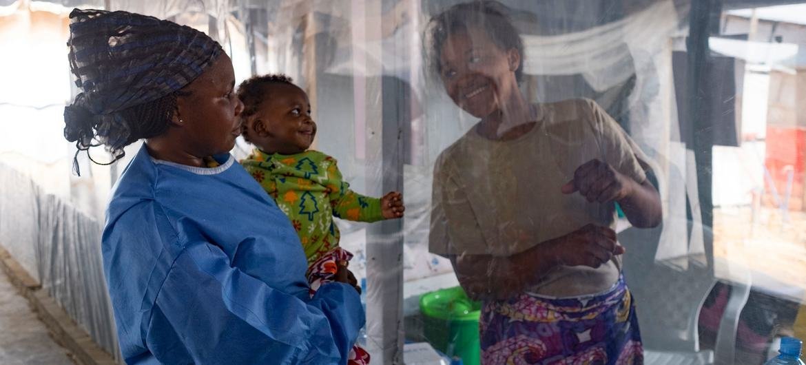 Un bebé de cinco meses sonríe cuando ve a su madre a través del plástico que los separa en un Centro de Tratamiento del Ébola (CTE) en Beni, provincia de Kivu del Norte, República Democrática del Congo.