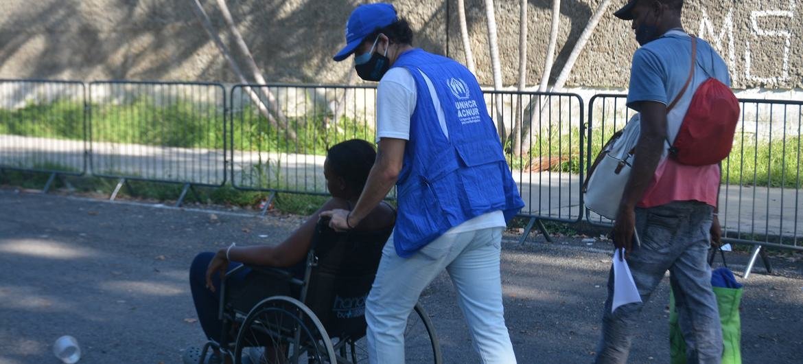 Personal de ACNUR asistiendo a una persona migrante en el Estadio Olímpico de Tapachula, Chiapas, en noviembre de 2021. 
