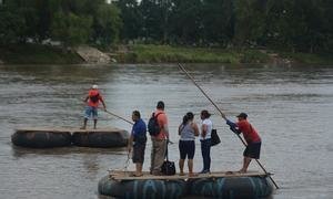 移民渡过一条位于危地马拉和墨西哥之间的边界河。