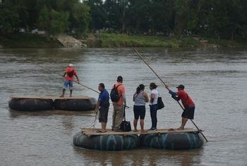 Un grupo de personas atraviesa el río Suchiate en una balsa en la frontera de Chiapas con Guatemala, México en noviembre de 2021.