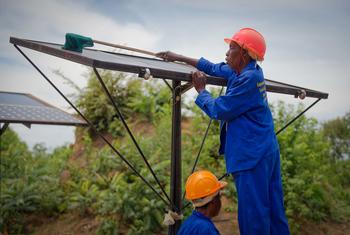 Un ouvrier installe un panneau solaire dans une coopérative agricole en Zambie.