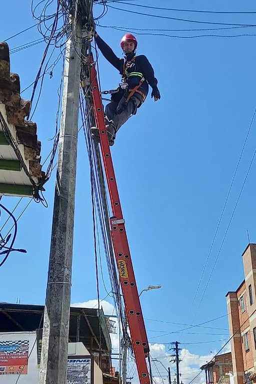 Camilo Andrey Vergara trabajando, subido en un poste de la luz. 