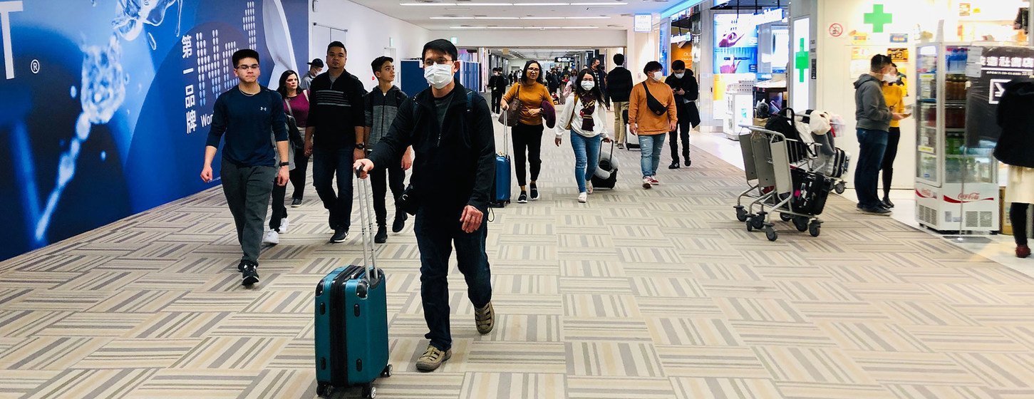 日本东京成田国际机场，人们戴着口罩。
