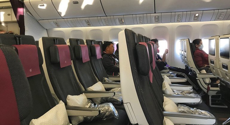 Vuelo de Doha, Qatar a la ciudad de Nueva York con pasajeros con mascarillas para protegerse del coronavirus