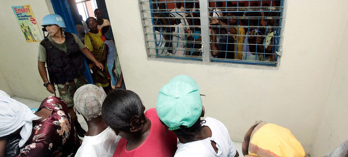 A member of the Peruvian Battalion serving with MINUSTAH guards a facility on the edge of Cité Soleil and Cité Militaire in Port-Au-Prince, Haiti, allowing people to come in and register.