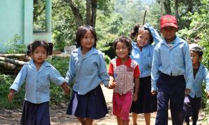 尼泊尔农村，一群小学生放学后手牵手走在路上。