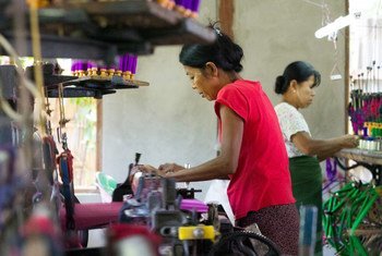 缅甸国内的移民劳工正在该国掸邦的首府东枝缝制传统服饰笼基。