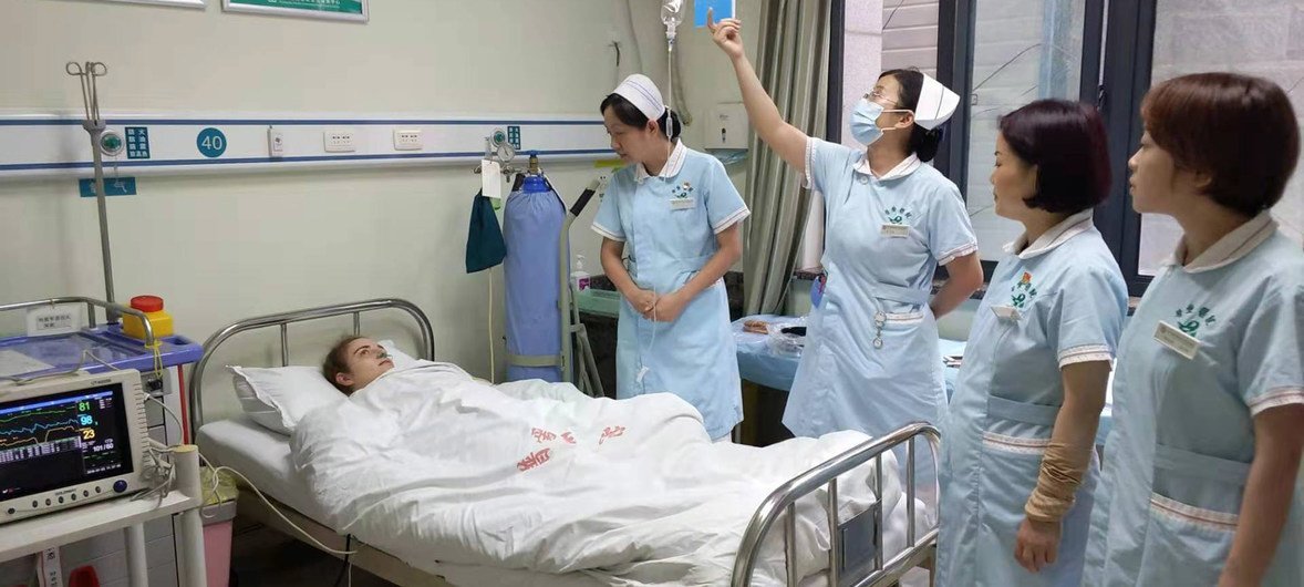 王志红护士长（病人旁边右一）正在给病人查房。