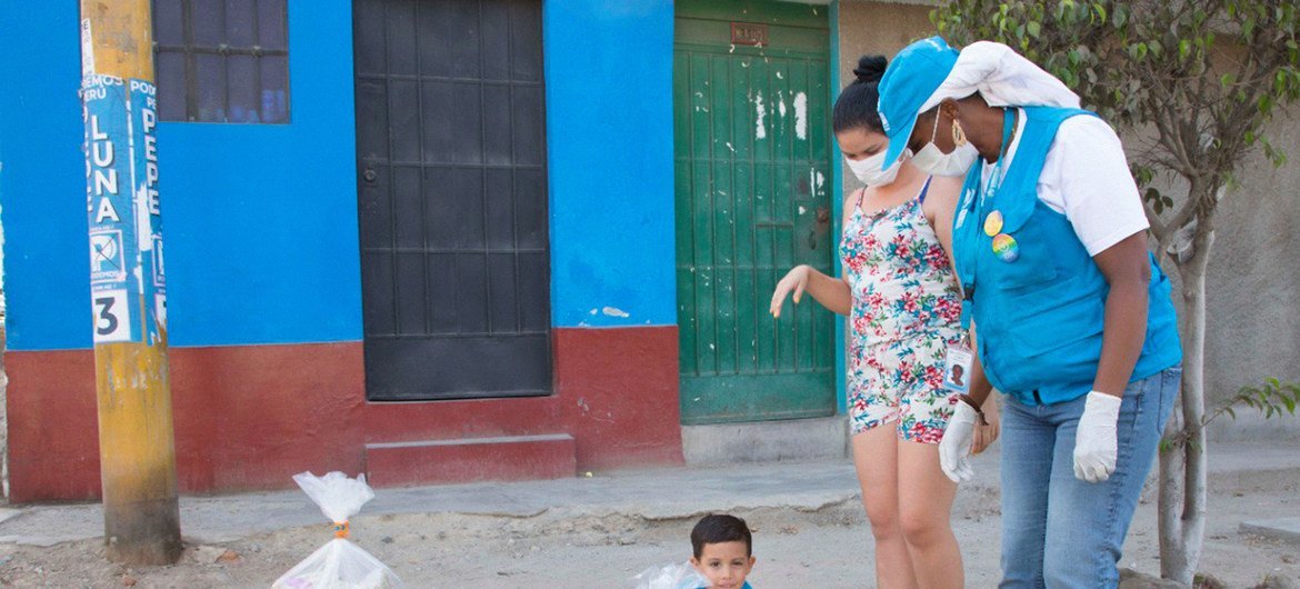 Mãe e filho recebem ajuda alimentar do Acnur em Lima, no Peru