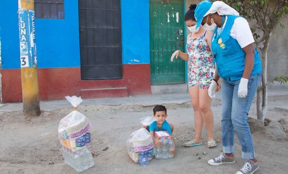 A child and his mother, both Venezuelans, receive food aid from UNHCR in Lima (file)