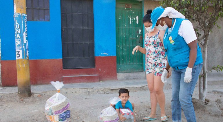 Un niño y su madre, ambos venezolanos, reciben ayuda de las agencias de la ONU en un barrio de Lima.