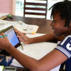 Une jeune fille étudie en ligne chez elle à Abidjan, en Côte d'Ivoire.