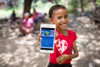 तिमोर-लेस्टे में एक लड़की एक मोबाइल प्लैटफ़ॉर्म दिखाती हुई जो वो स्कूल बन्द रहने पर अपनी शिक्षा जारी रखने के लिए इस्तेमाल करेगी. 