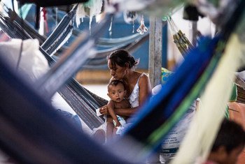 在巴西的平托兰迪亚（Pintolandia），一位母亲在体育馆改造的难民安置点内照顾自己的孩子。