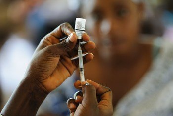 घाना के एक स्वास्थ्य केंद्र में एक नर्स, सिरींज में वैक्सीन भर रही है.