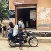ग्रामीण भारत में एक सरकारी राशन की दुकान पर मोटरसाइकिल पर सवार एक पुरुष और एक महिला, WFP के नवाचार, ग्रेन एटीएम से अनाज की बोरियां प्राप्त करते हैं।