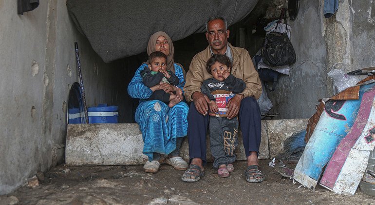 Familia ya wakimbizi wa ndani wakiishi katika shule iliyoharibiwa kwenye mji wa Binish, Idlib, Syria