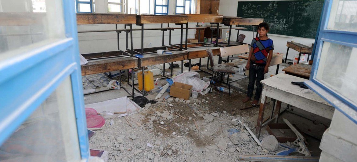 在位于加沙地带的一所学校里，一名巴勒斯坦学生站在因加沙哈马斯与以色列的冲突而被损坏的教室里。（资料图片）